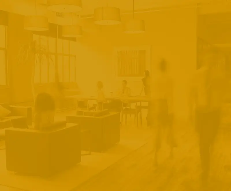 A busy office with people working at their desks and moving around the office